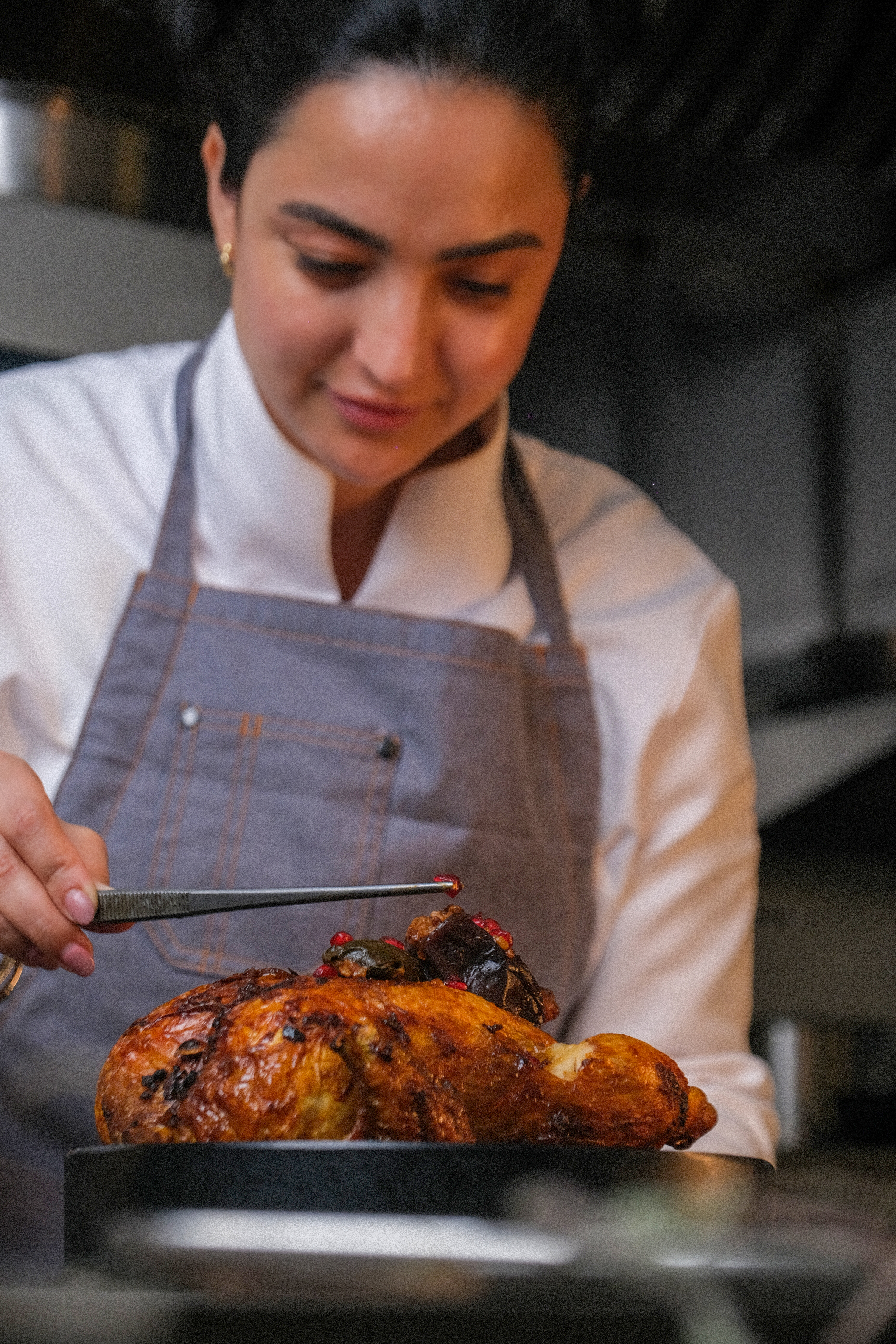 Chef basting a whole roasted chicken
